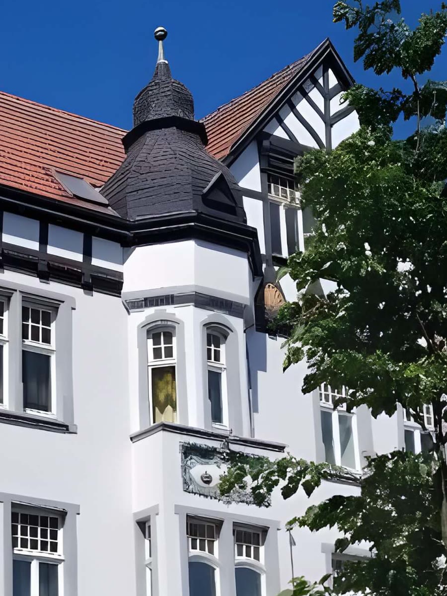 Detail der Fassade: schiefergedeckter Erkerturm mit Kugelspitze, Fachwerkgiebel und Sprossenfenster